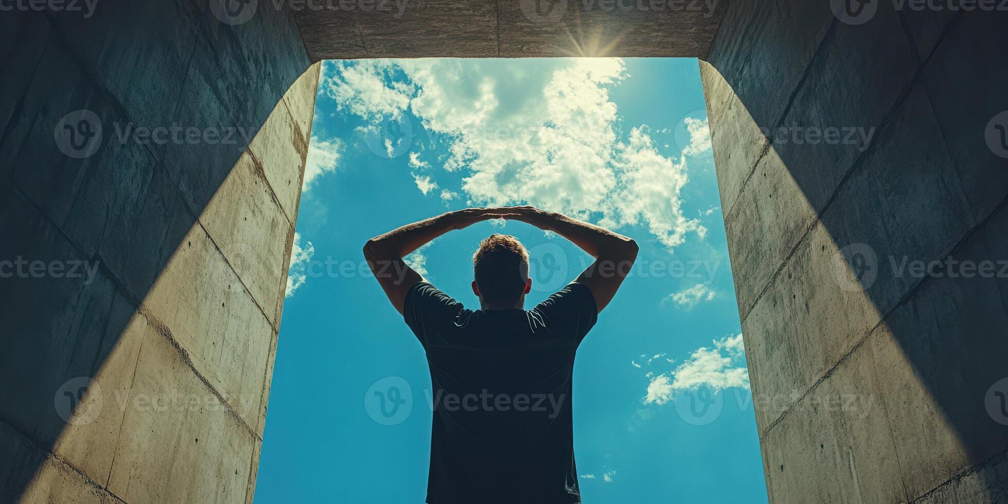 Person enjoying a moment of reflection under a clear blue sky in an urban setting during the day photo