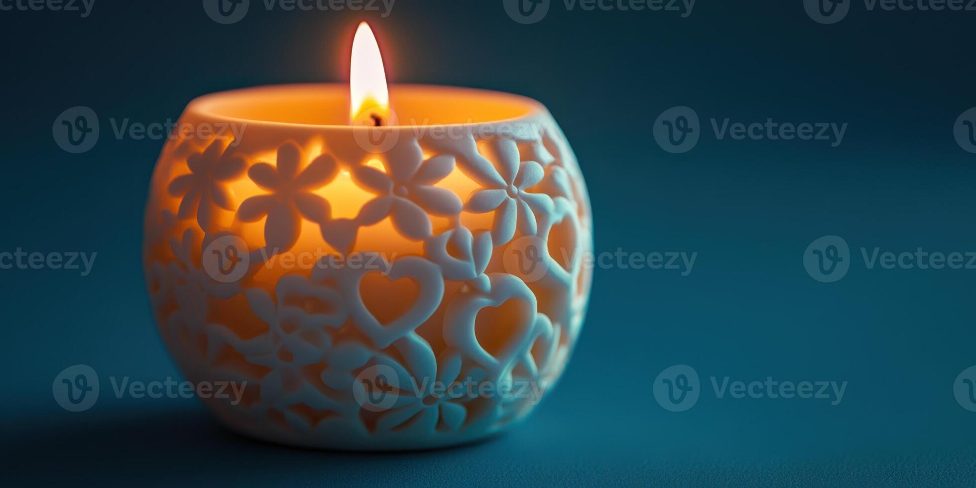 Decorative candle holder with floral design casting warm light on blue background photo