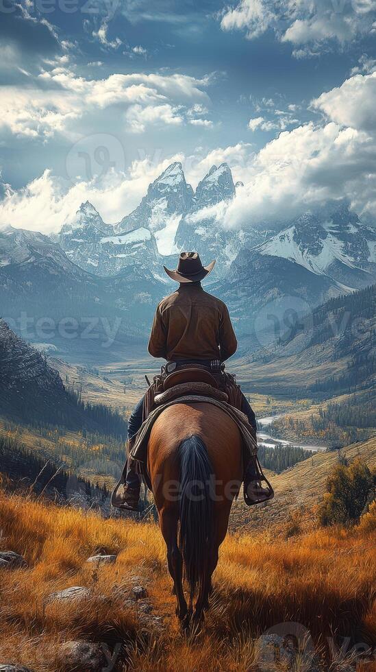 Cowboy riding a horse in front of majestic mountains during a cloudy afternoon in the wilderness photo