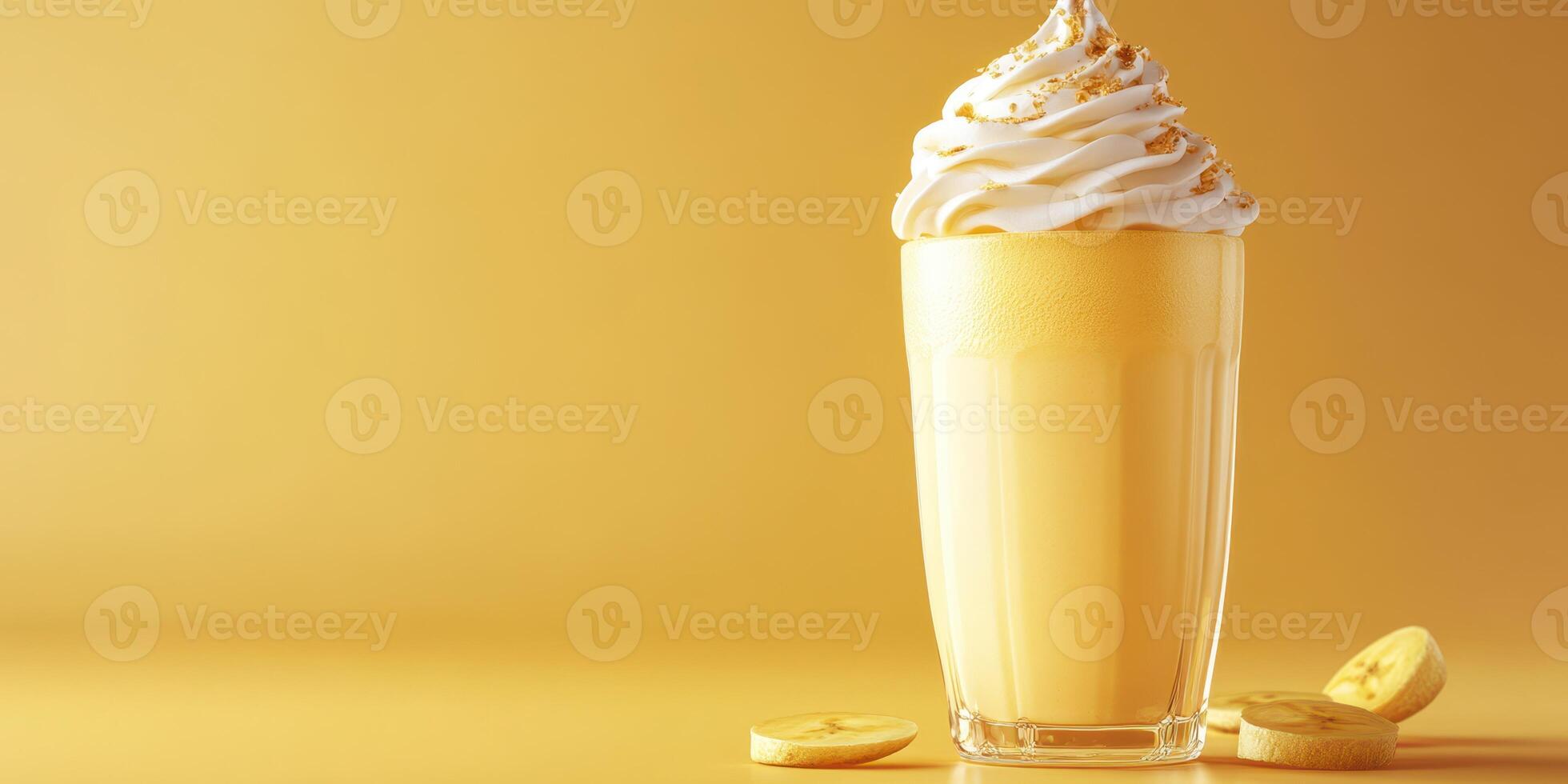 Creamy banana milkshake topped with whipped cream and golden sprinkles on a warm yellow background photo