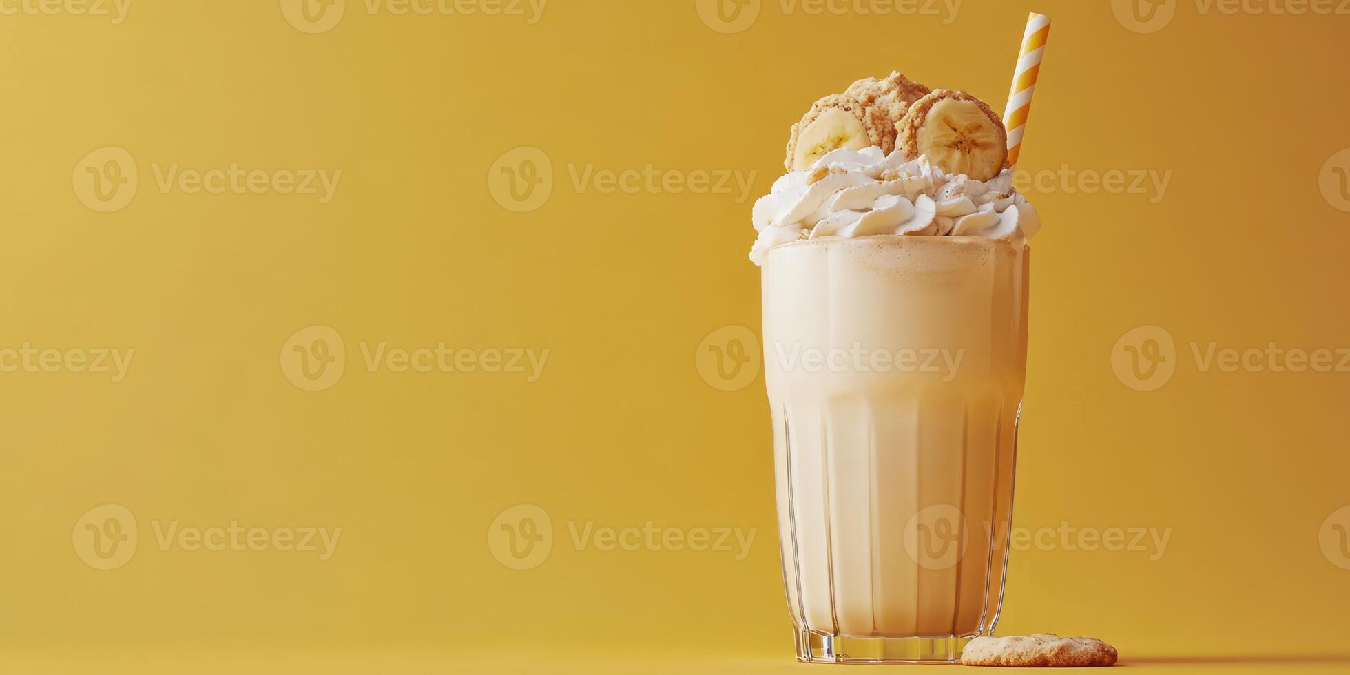 Creamy banana milkshake topped with whipped cream and cookies on vibrant yellow background photo