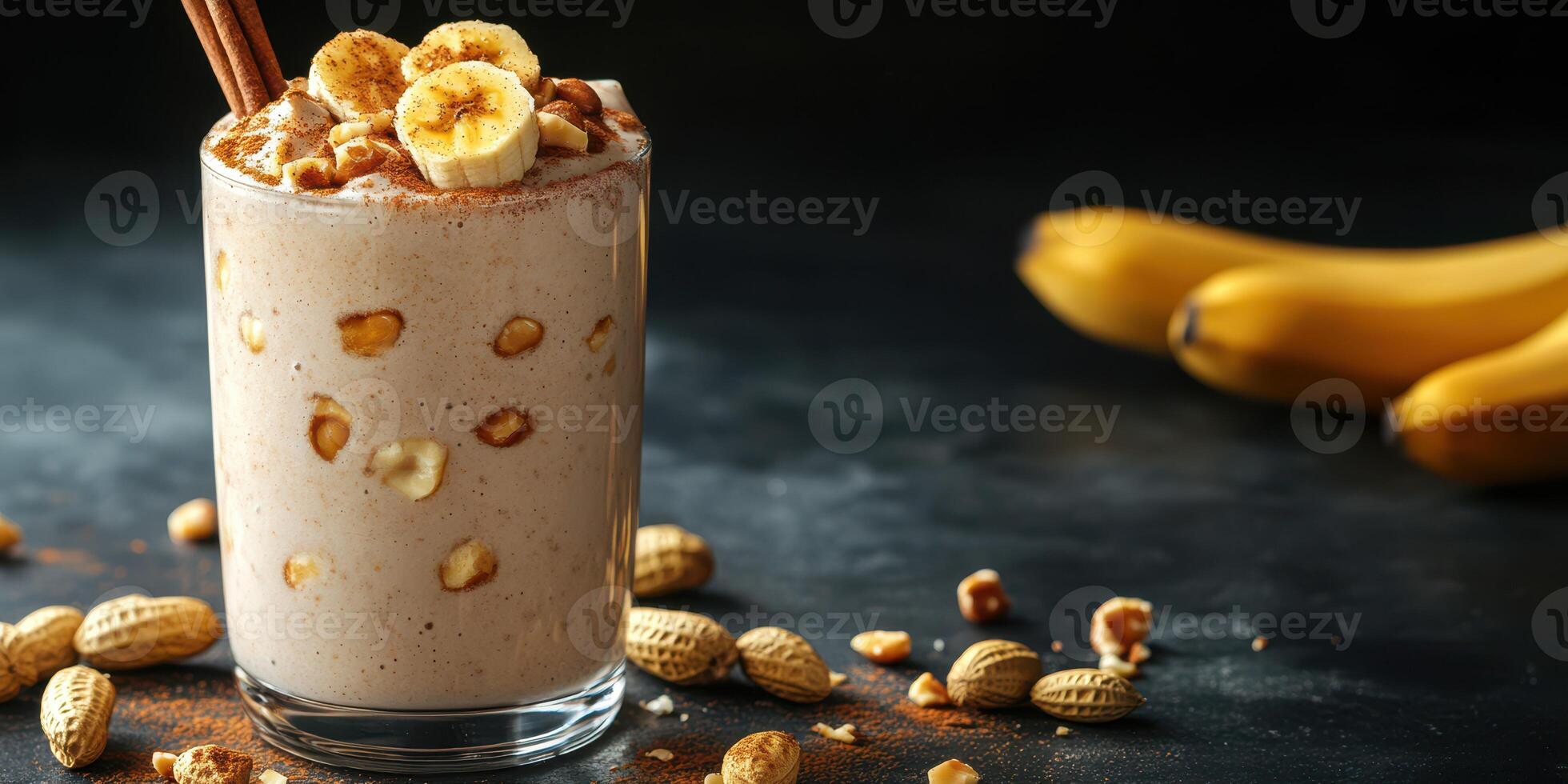 Delicious banana smoothie with peanuts served in a glass beside fresh bananas and scattered nuts on a dark background photo