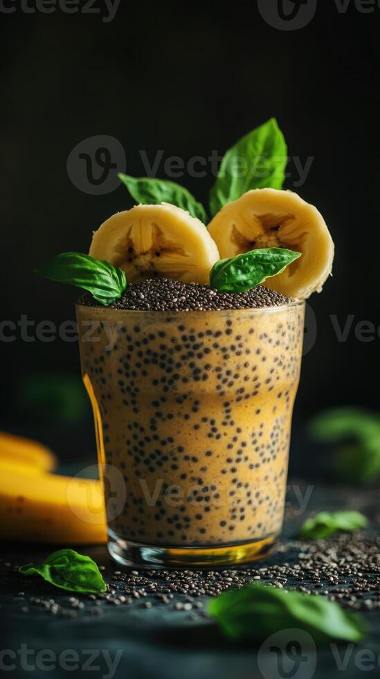 Healthy banana chia seed smoothie with fresh basil leaves and banana slices served in a glass cup photo