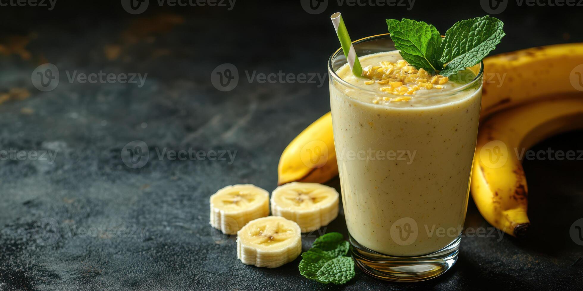 Creamy banana smoothie served in a glass with fresh mint and sliced bananas on a dark textured background photo