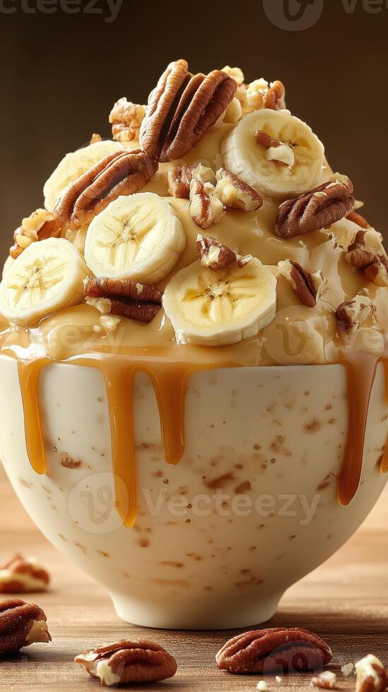 Delicious bowl of ice cream topped with caramel, bananas, and pecans on a wooden table perfect for dessert lovers photo