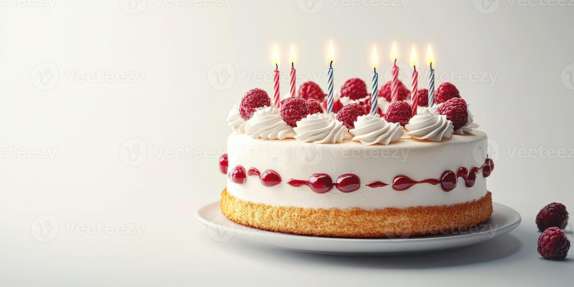 Birthday cake with lit candles and raspberries on a white background ready for celebration photo