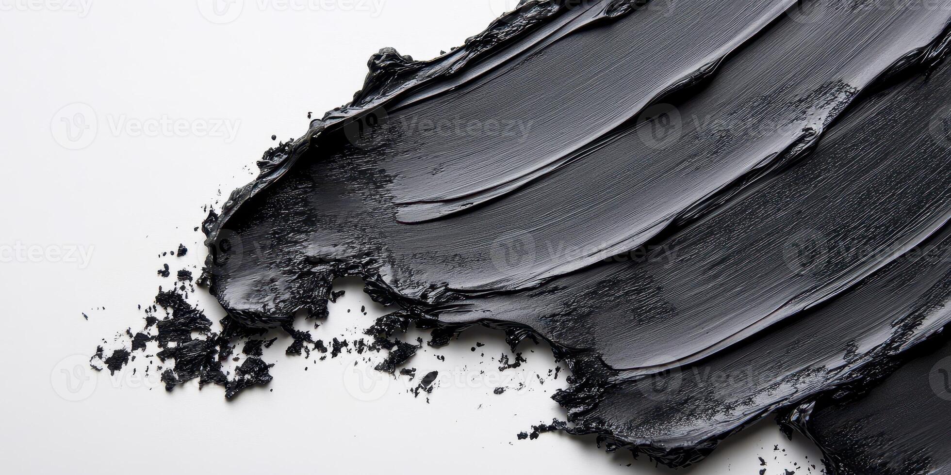 Thick black paint smeared across a white surface creates a striking contrast in abstract art composition photo