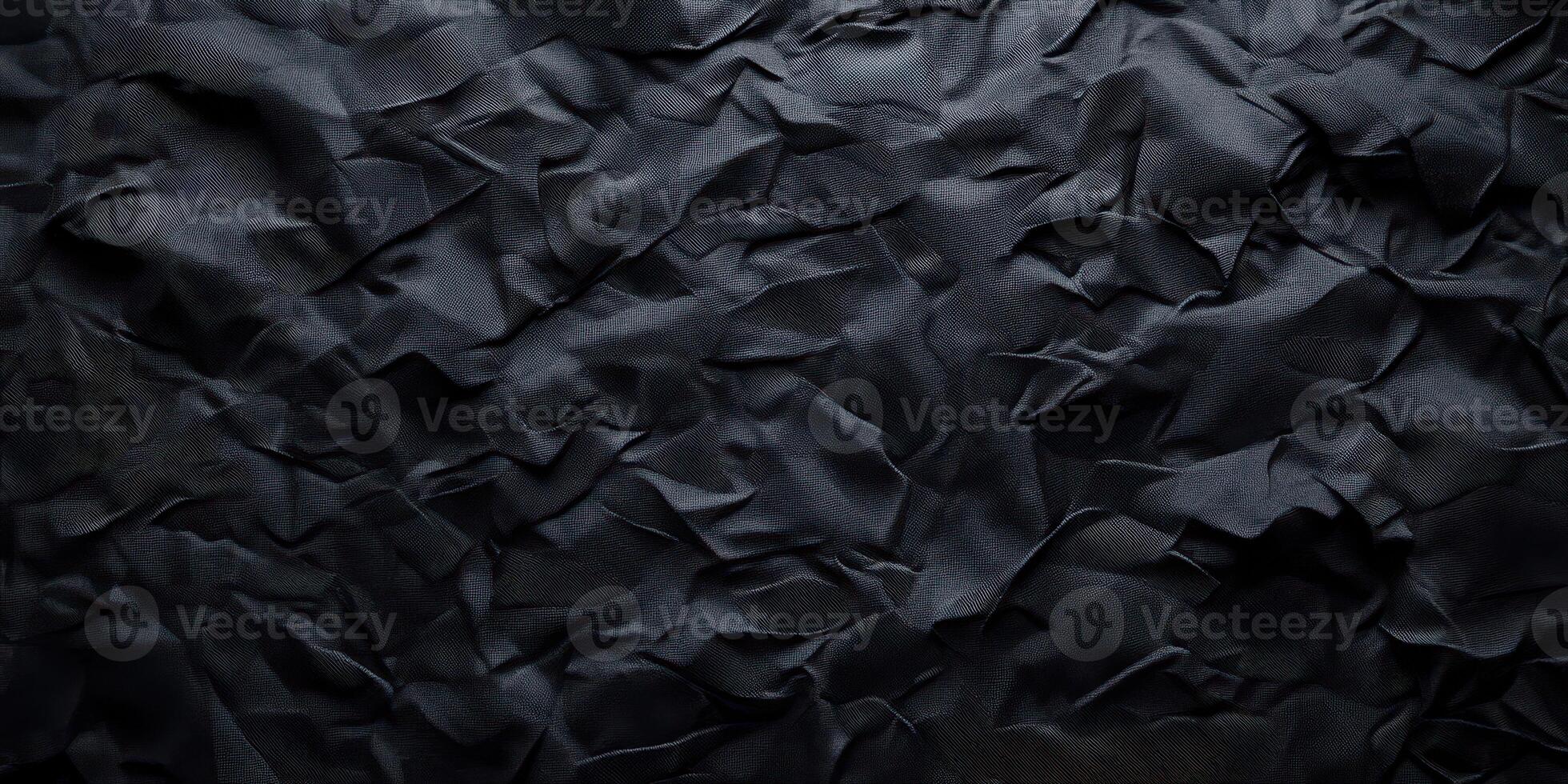 Crumpled black paper texture showcasing intricate folds and shadows in artistic, abstract form photo