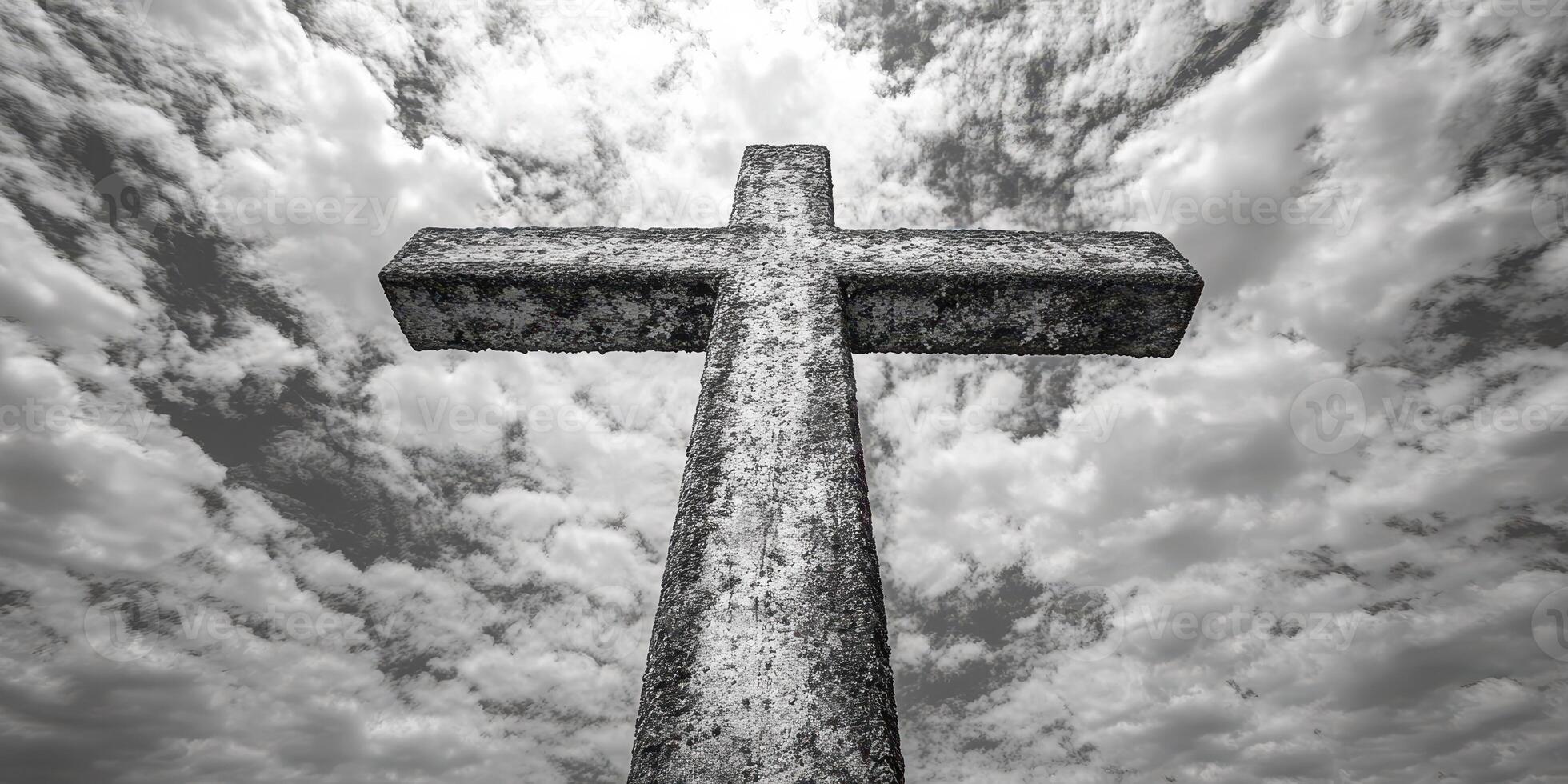 Stone cross stands tall against a cloudy sky in a solemn setting conveying reverence and memory photo