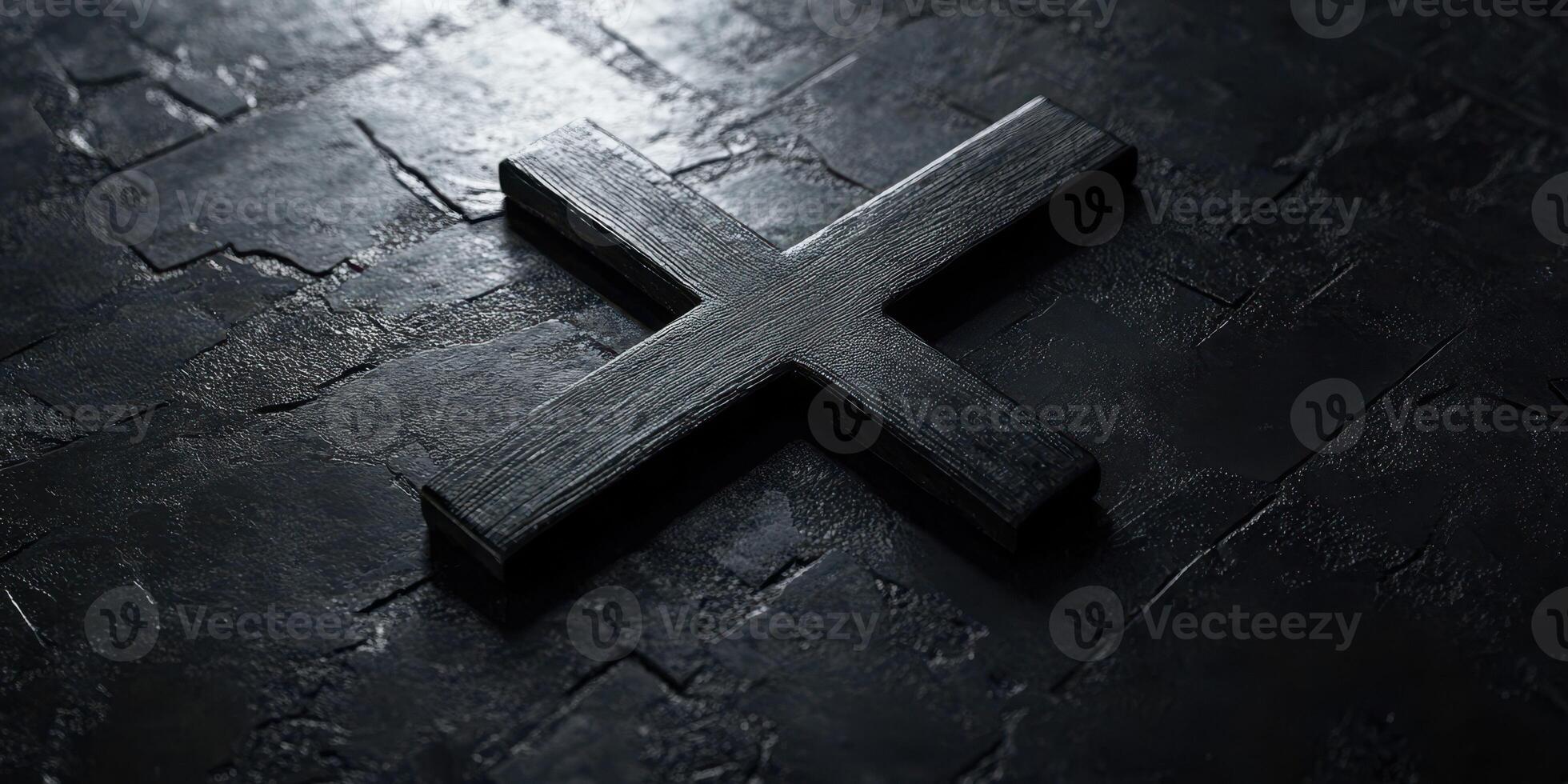 Dark wooden cross resting on a textured stone surface illuminated by soft light photo