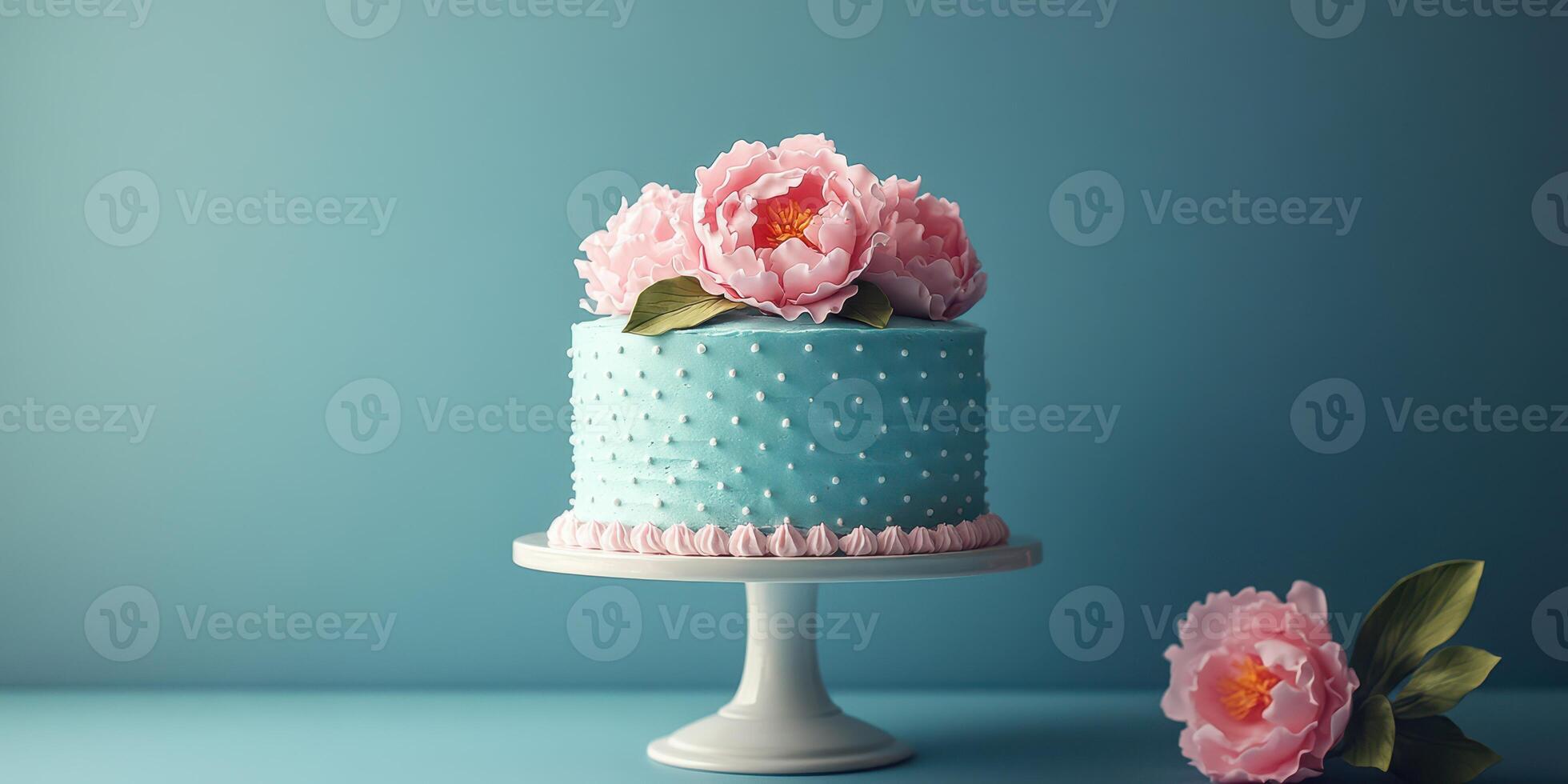Decorative blue cake adorned with pink flowers on a stand in a bright setting for a celebration photo