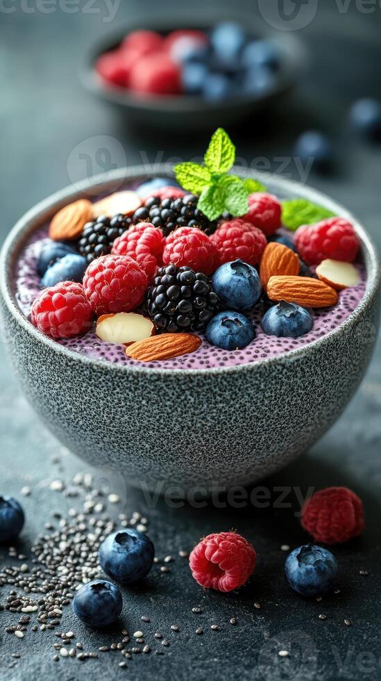 Fresh fruit and nuts topped smoothie bowl served with a colorful array of berries and almonds on a dark background photo