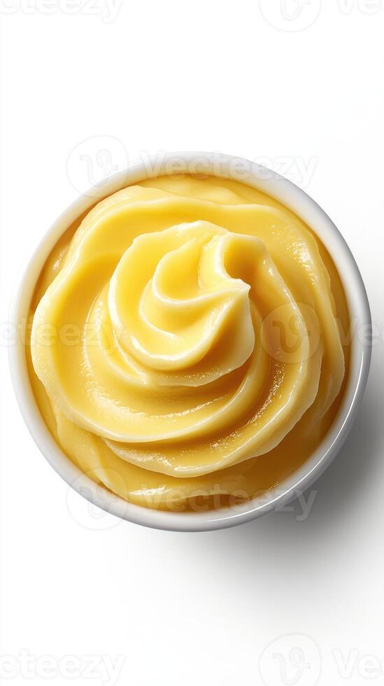 Creamy yellow dessert in a white bowl with a smooth swirl, perfect for various sweet dishes and toppings photo