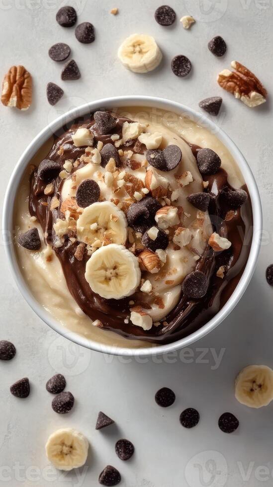 Delicious bowl of banana pudding topped with chocolate, nuts, and chips for a delightful treat photo