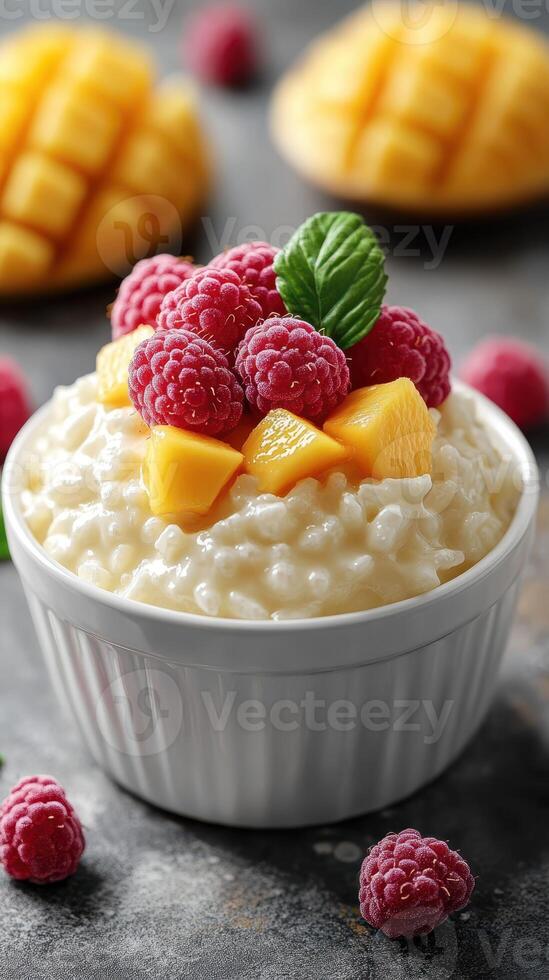 Delicious bowl of creamy rice pudding topped with fresh raspberries and mango slices in a cozy kitchen setting photo