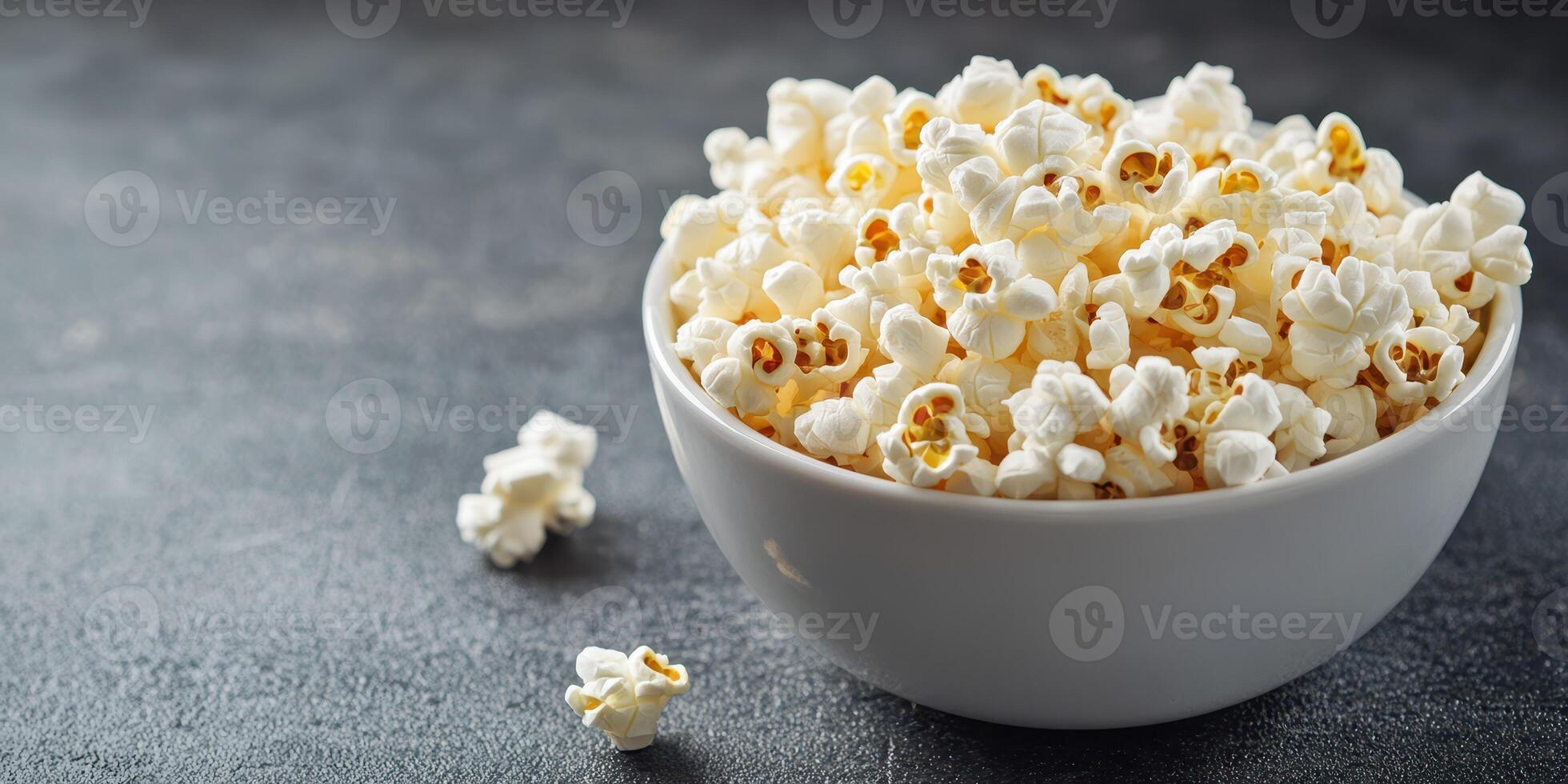 Freshly popped popcorn served in a white bowl, perfect for movie nights or snacks on a relaxing evening photo