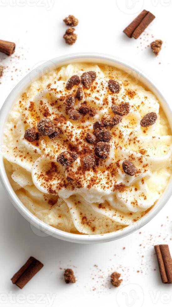 Creamy dessert topped with whipped cream, spices, and cookie crumbles in a bowl on a light background photo