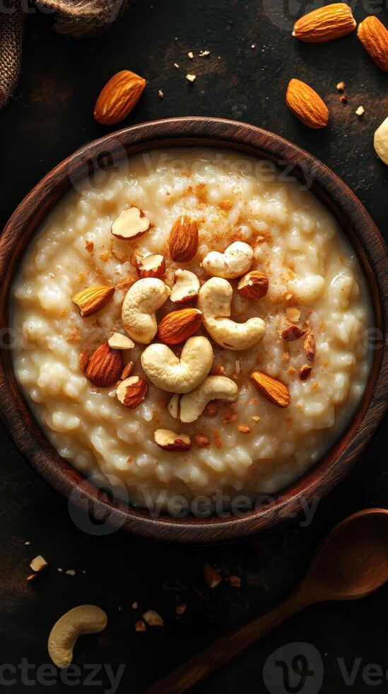 Warm bowl of creamy rice pudding garnished with nuts and spices in a rustic setting photo