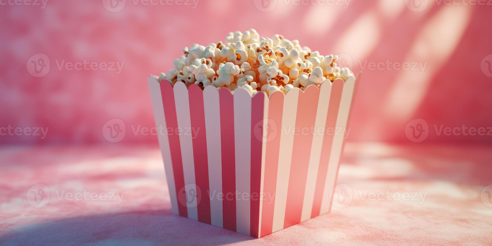Delicious popcorn in a pink striped container against a soft pink background, perfect for movie night or a fun gathering photo