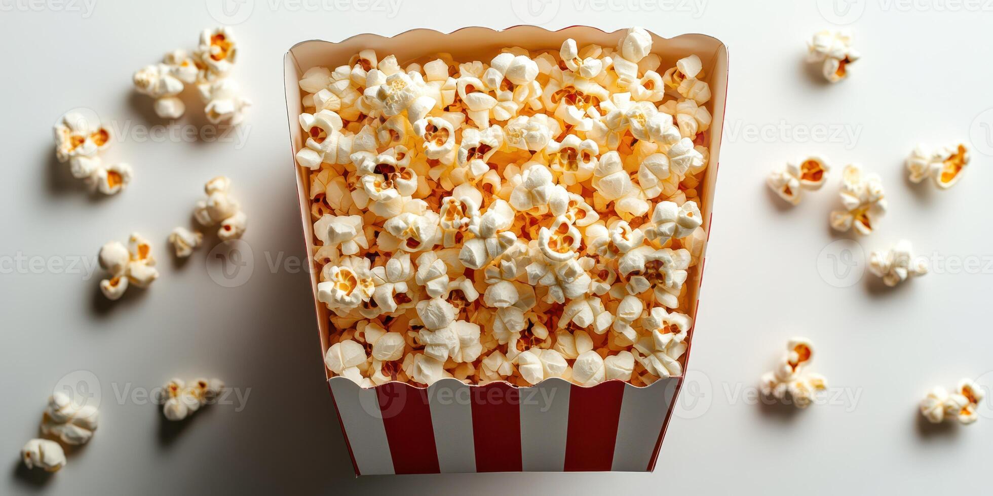 Popcorn served in a classic red and white striped box on a light backdrop, perfect for movie nights or festivities photo
