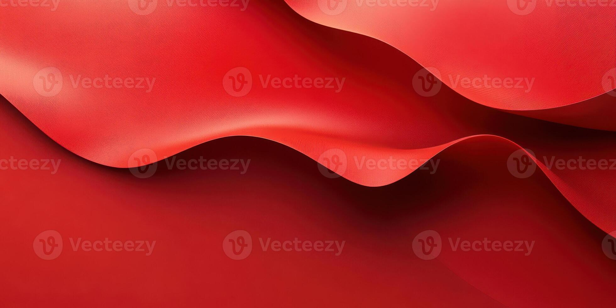 Red fabric drapes flowing elegantly across a surface with soft curves and folds creating a dynamic visual texture photo