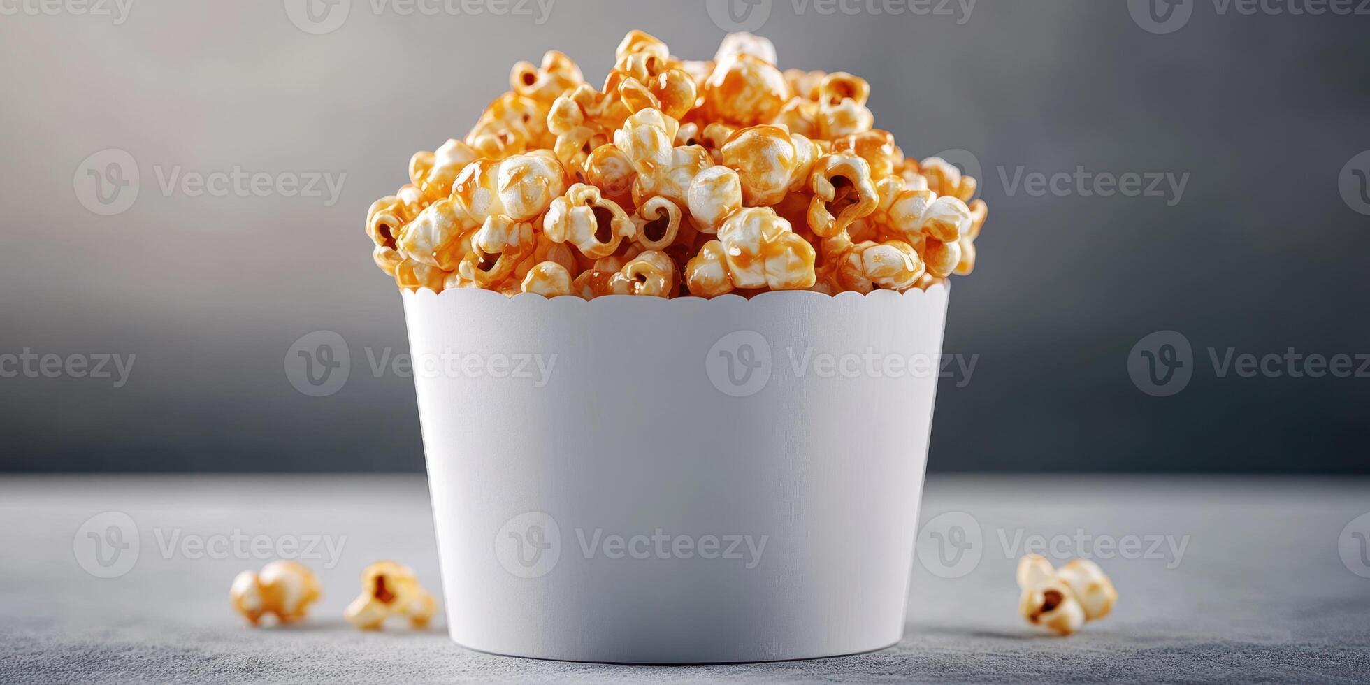 Freshly popped buttered popcorn served in a white container on a simple gray background photo