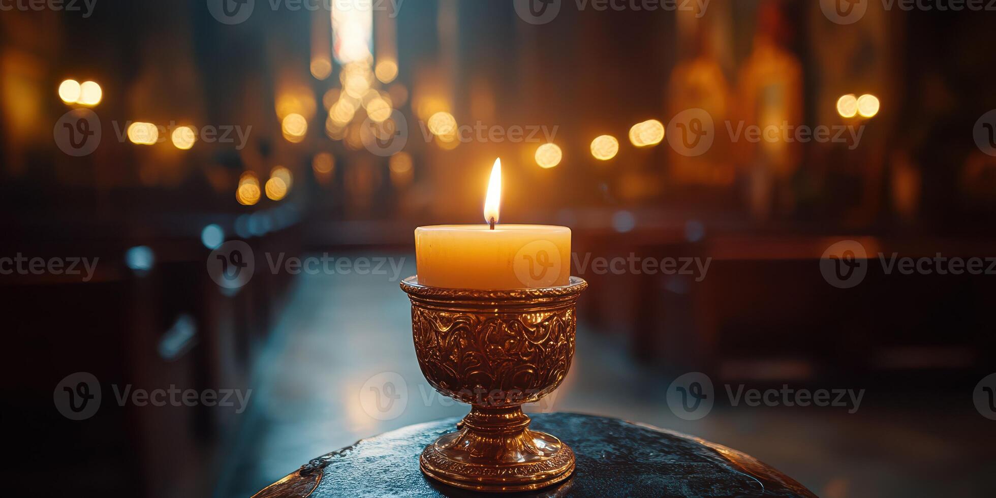 Candle burning in a dimly lit church, creating a serene atmosphere during evening worship photo