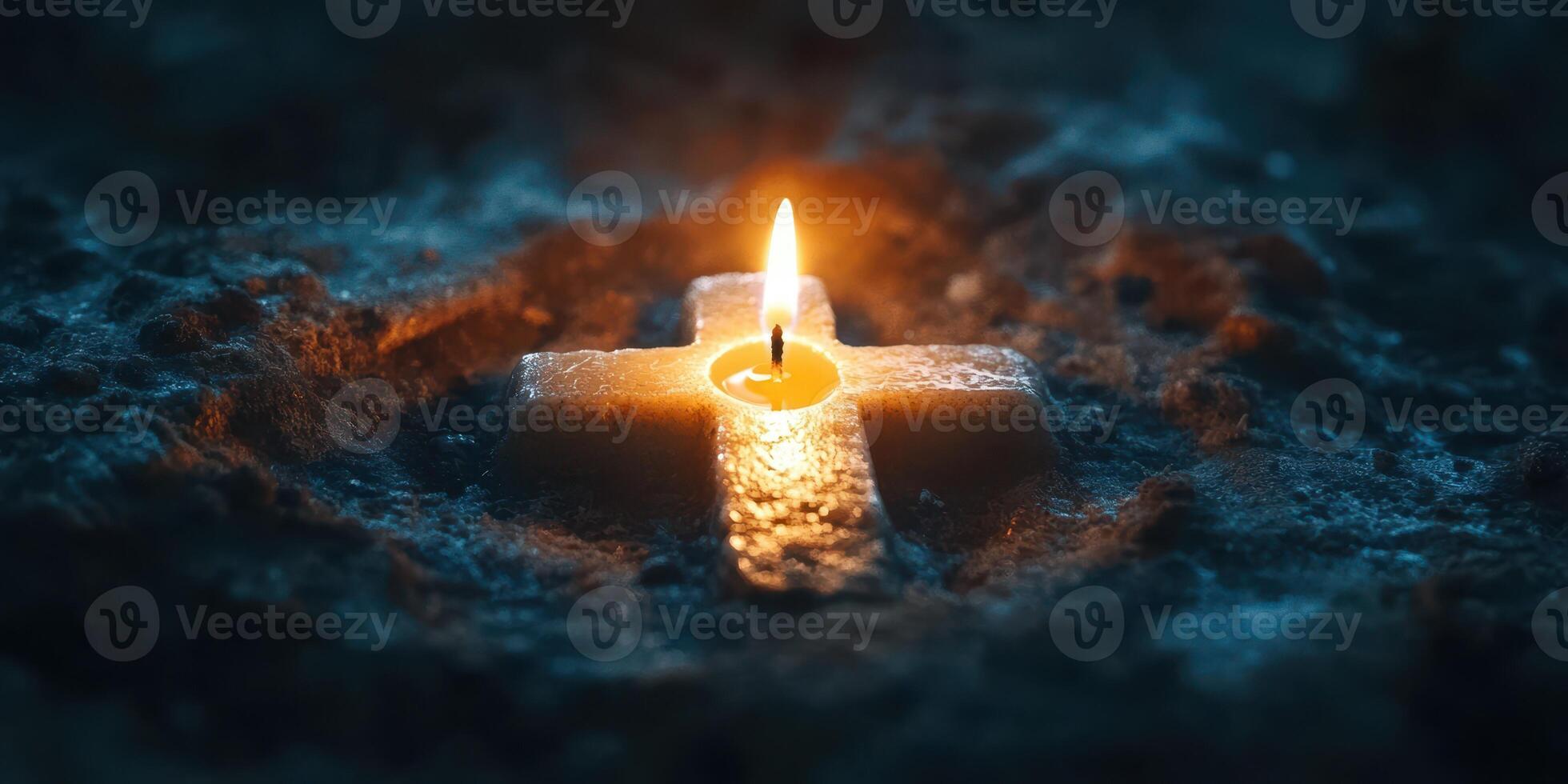 Candle illuminates a stone cross in a dimly lit space during a contemplative moment of reflection photo