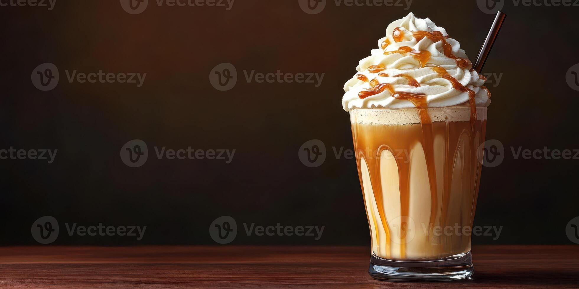 Rich caramel cream dessert drink served in a tall glass with a straw on a wooden table in a dim setting photo