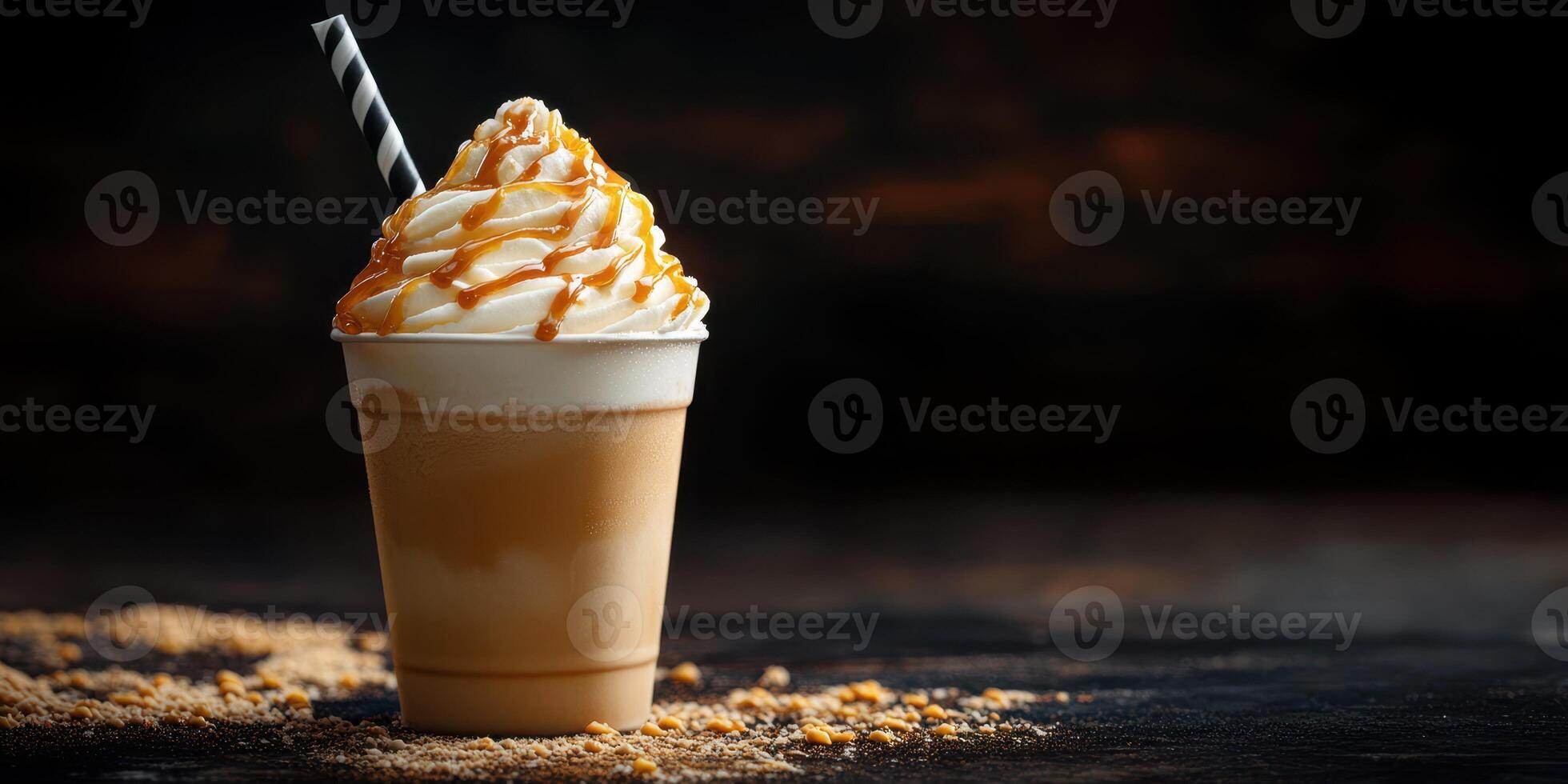 Delicious caramel milkshake with whipped cream and straw, served in a cup on a dark background photo