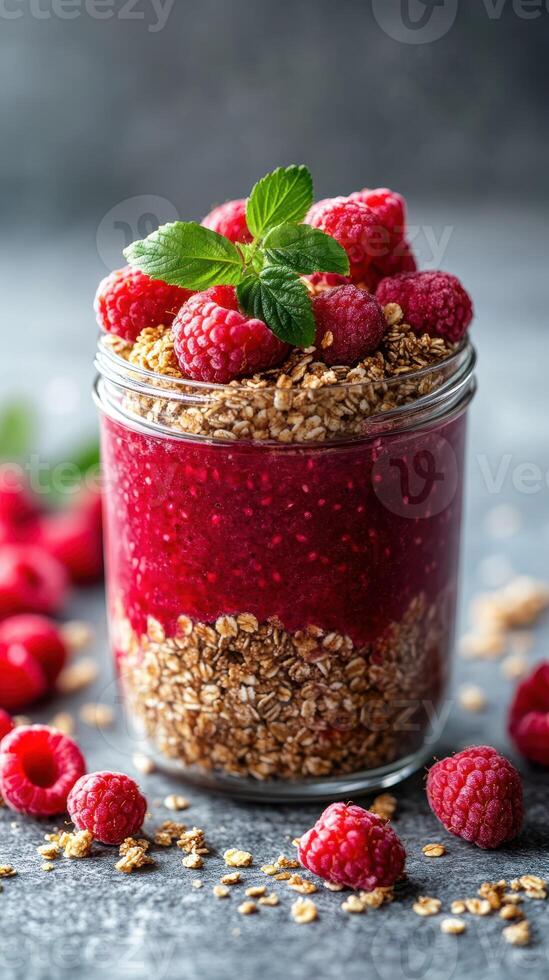 Delicious raspberry parfait layered with granola and fresh berries in a reusable jar photo
