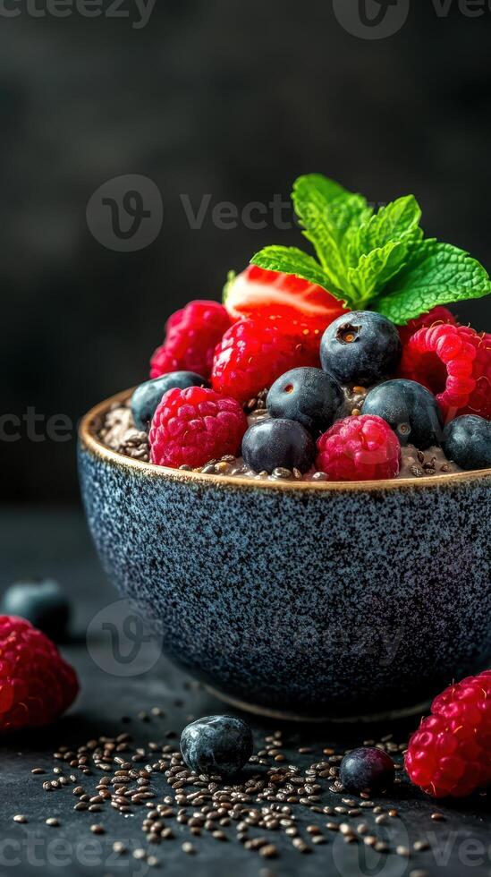Berry bowl with chia seeds and mint garnishment on a dark background photo