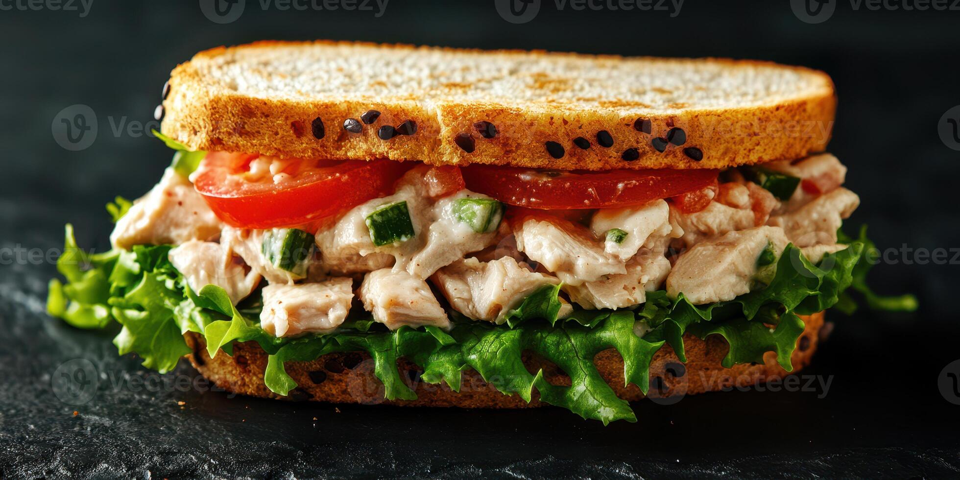 Delicious chicken salad sandwich on whole grain bread with lettuce and tomatoes prepared for lunch close to dinnertime photo