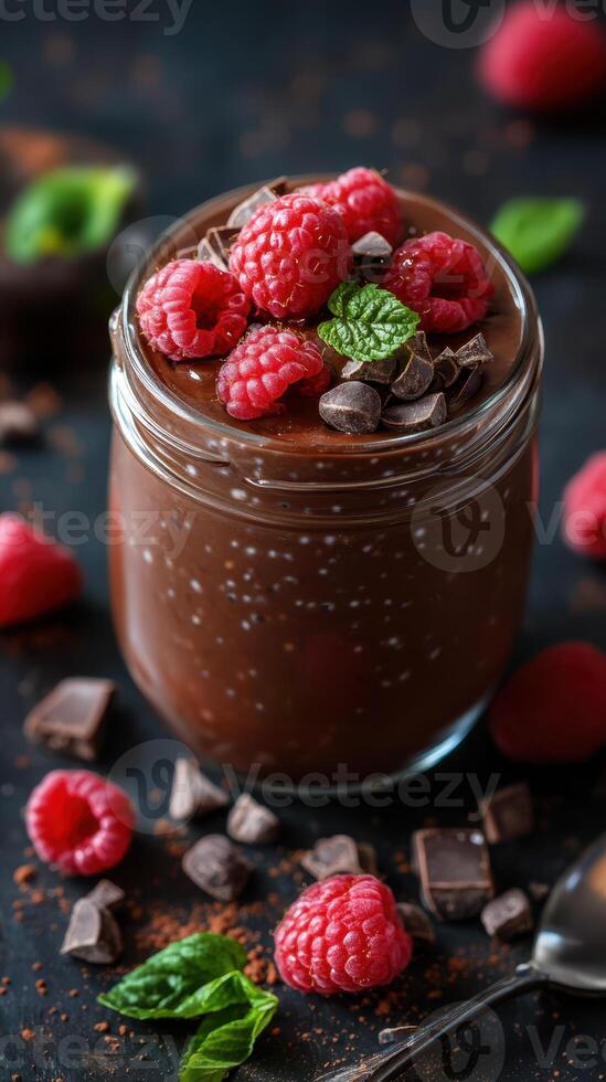 Indulgent chocolate dessert topped with fresh raspberries and mint served in a glass jar for a delightful treat photo