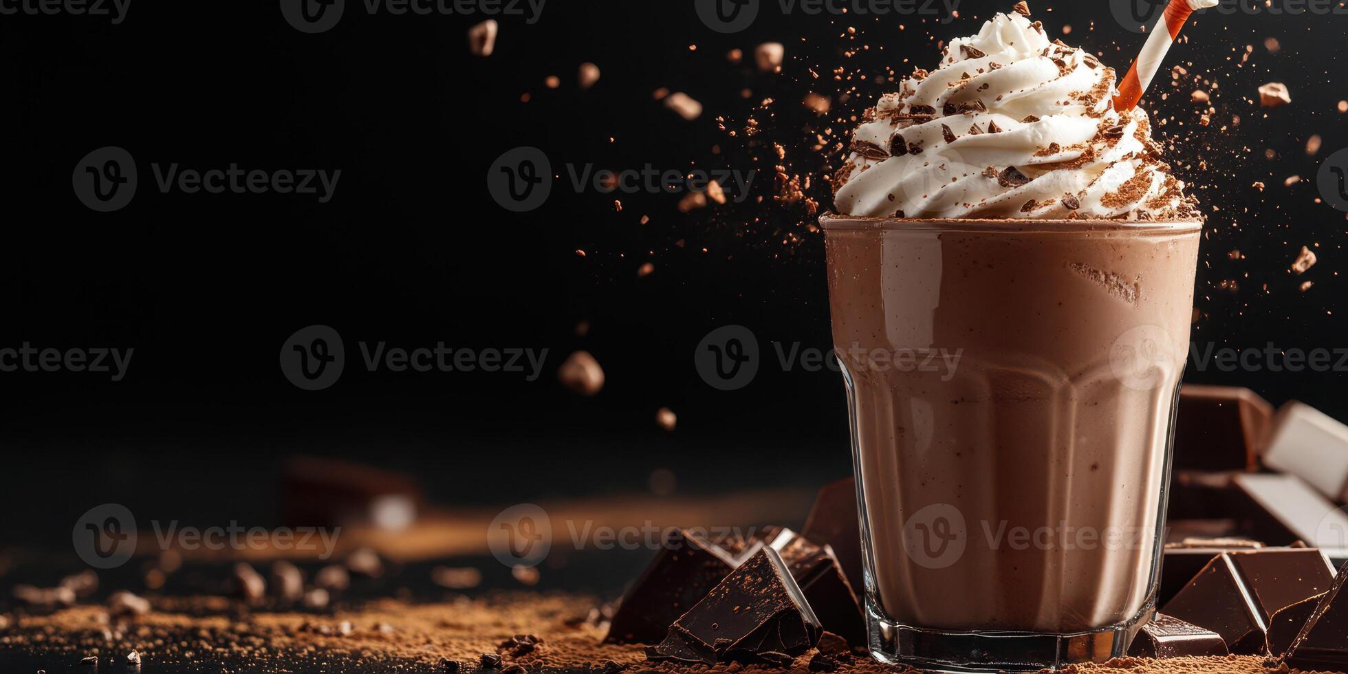 Rich chocolate shake topped with whipped cream and chocolate shavings enjoyed on a dark backdrop photo