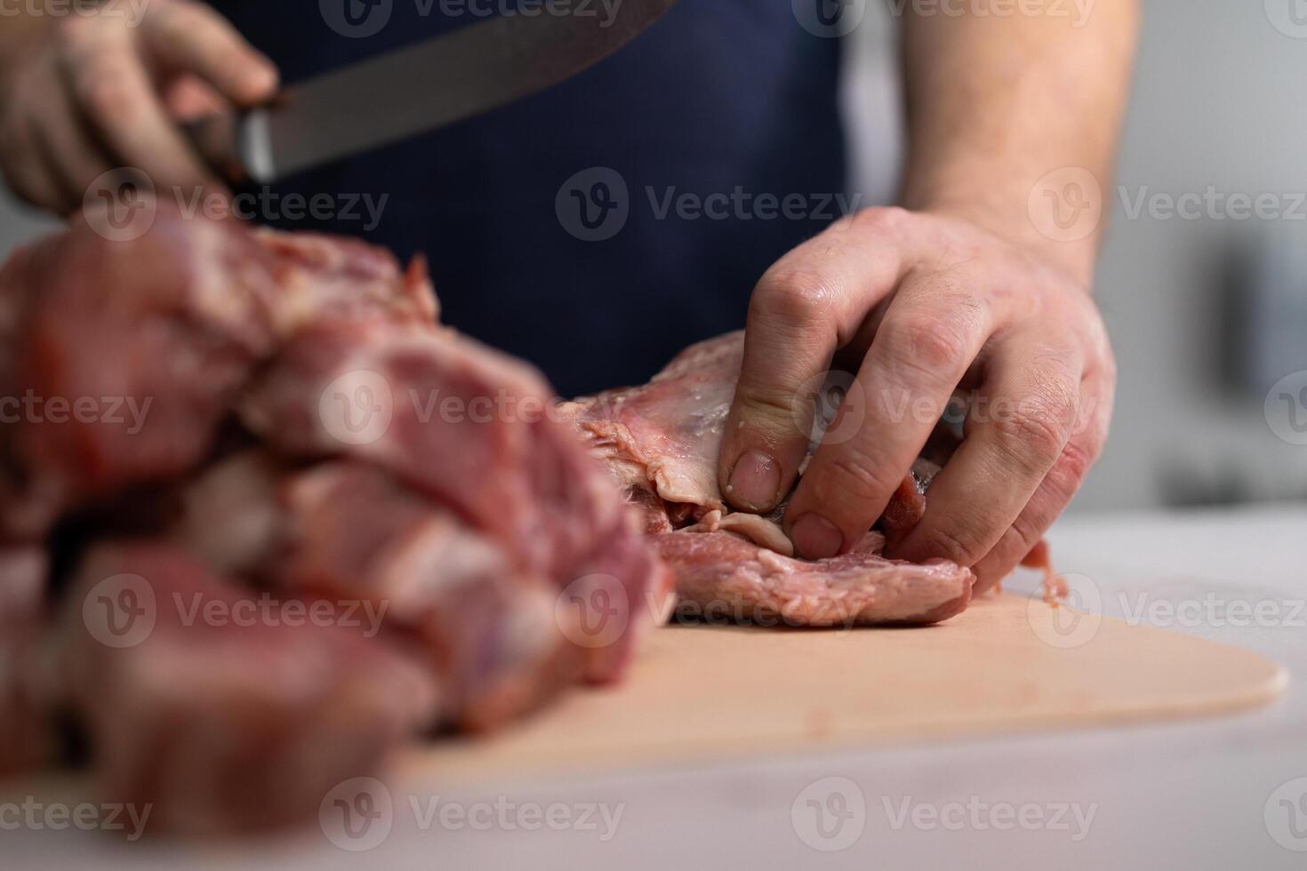 Talented Butcher Hands Skillfully Preparing Fresh Meat in a WellEquipped Kitchen Setting photo