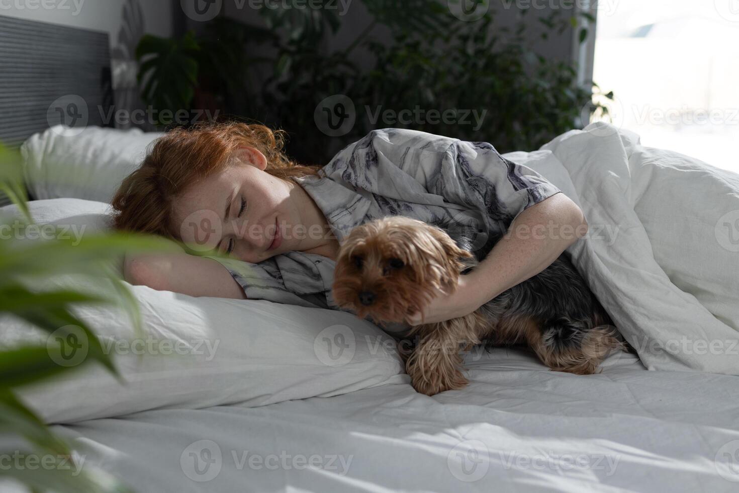 Cozy Morning A Woman Snuggling Enthusiastically with Her Dog While Relaxing in Bed photo