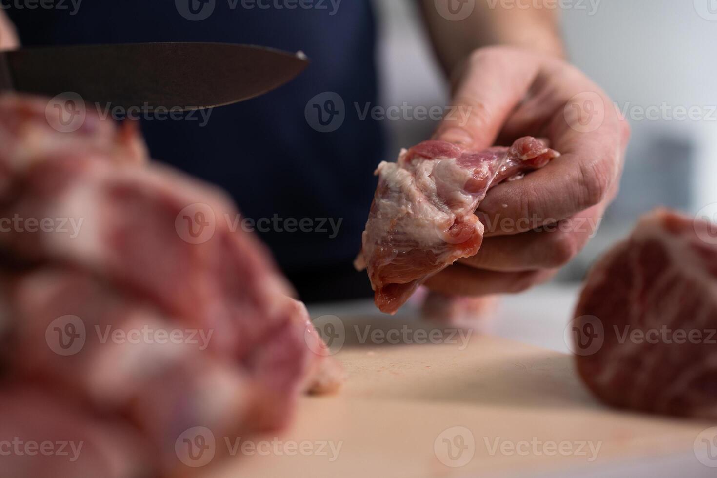A skilled chef is meticulously preparing fresh and flavorful meat cuts for culinary dishes photo