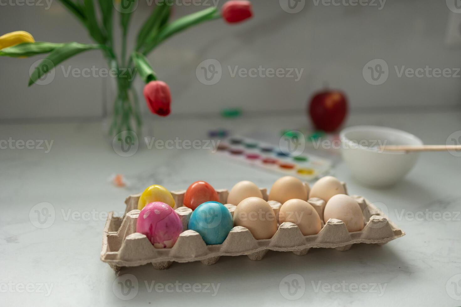A gorgeous display of Colorful Easter Eggs alongside a beautiful Floral Arrangement on the Table photo