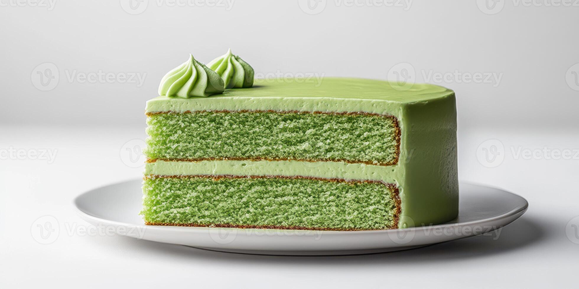 Moist green tea cake with smooth frosting and decorative swirls on top displayed on a white plate photo