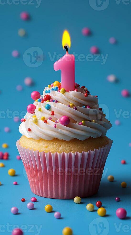 Colorful cupcake with a pink candle for a first birthday celebration on a blue background photo