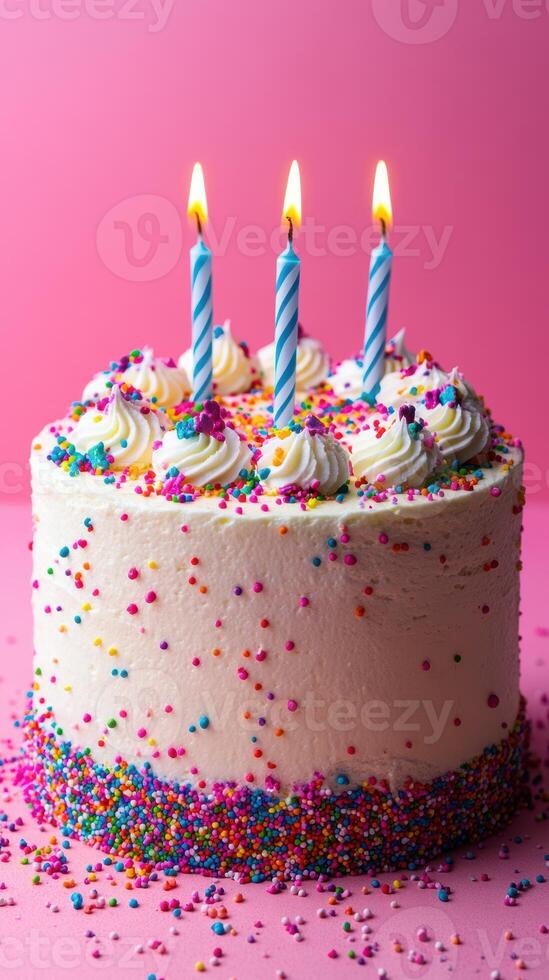 Bright and festive birthday cake with three candles glowing on top surrounded by colorful sprinkles on vibrant pink background photo