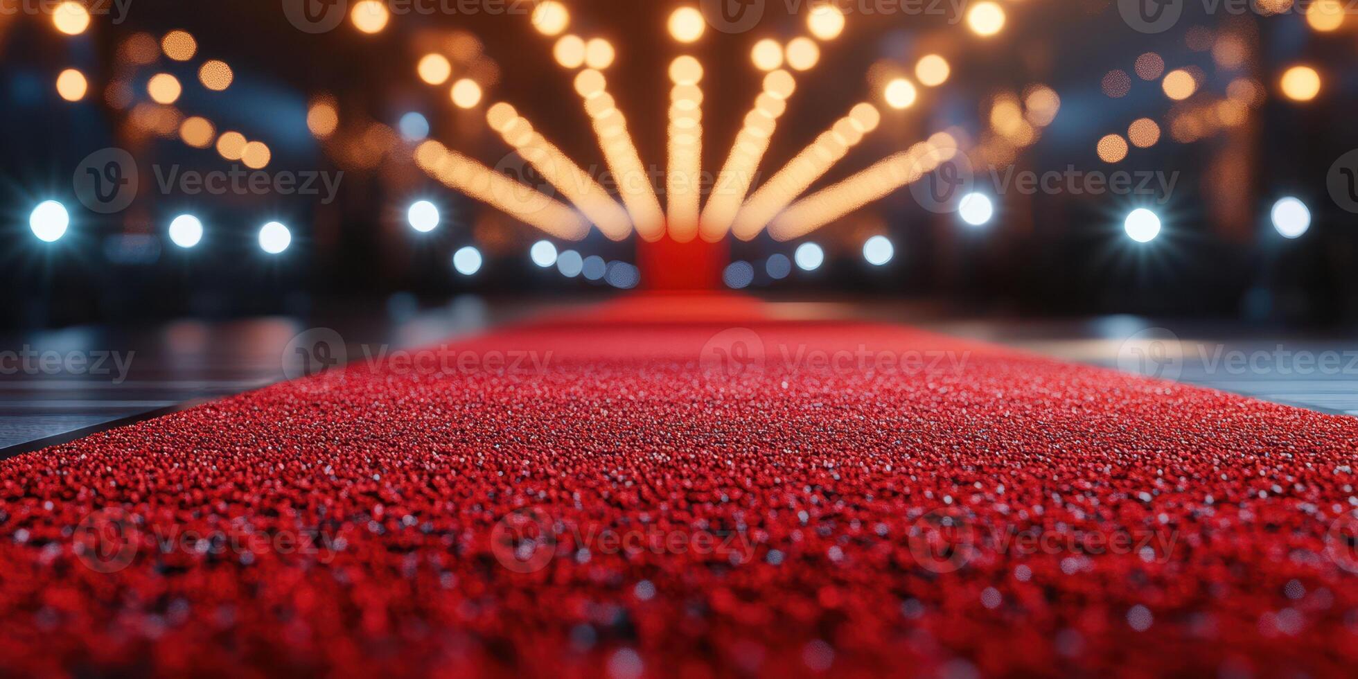 Elegant red carpet leading to a dazzling stage adorned with bright lights at a glamorous event venue photo