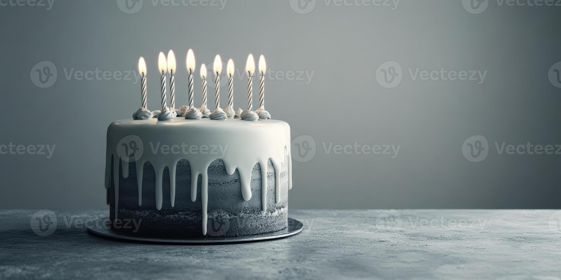 Elegant birthday cake with candles lit on a simple gray background photo