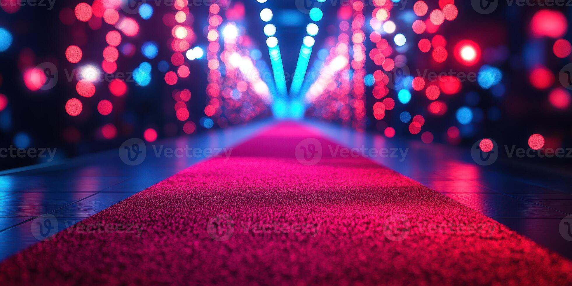 Bright lights illuminate a vibrant red carpet pathway at a glamorous event photo