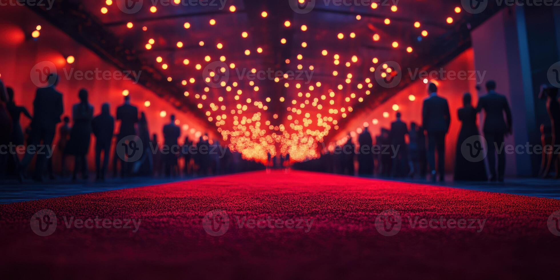 Elegant red carpet event illuminated by warm lights at night with guests mingling in formal attire photo