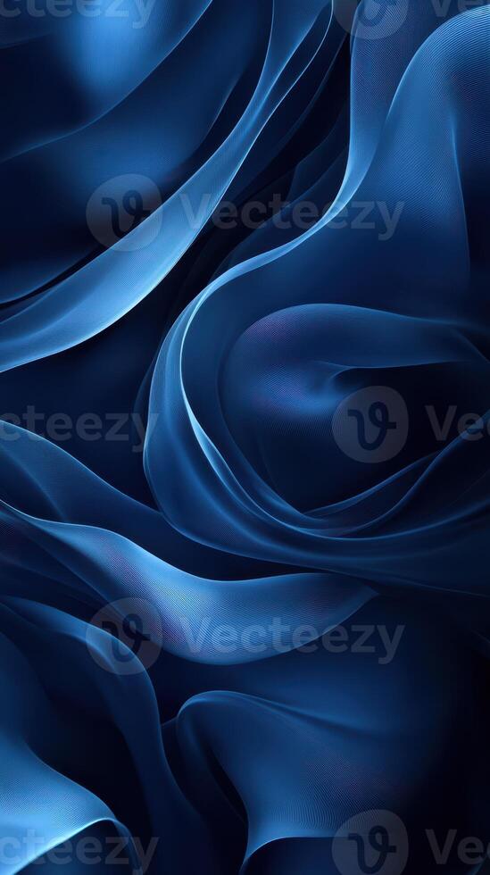 Swirling blue silk fabric creating a soft, flowing texture in a deep shadowed composition photo