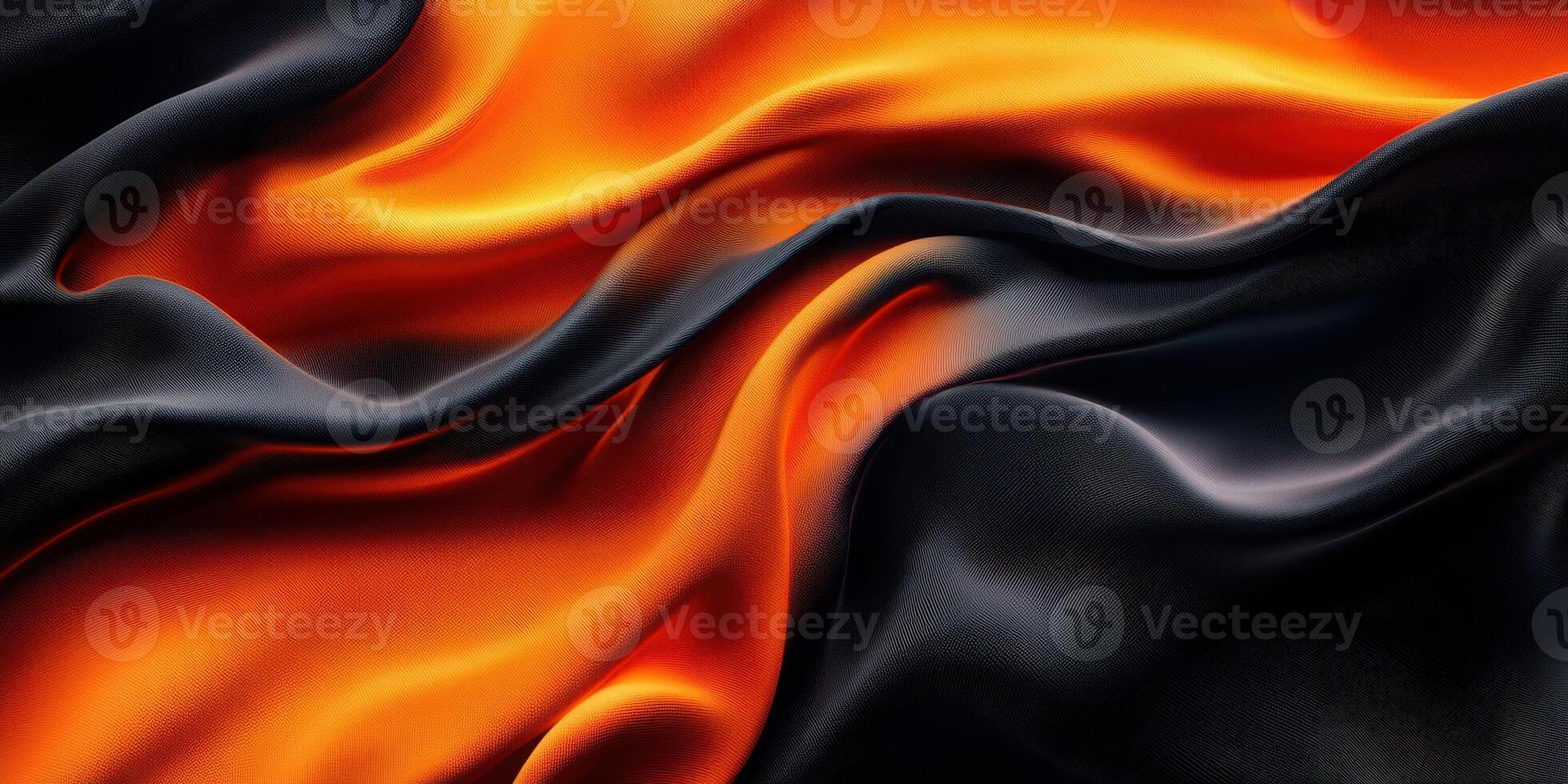 Silky black and orange fabric drapes elegantly with smooth folds under soft lighting in a cozy setting photo