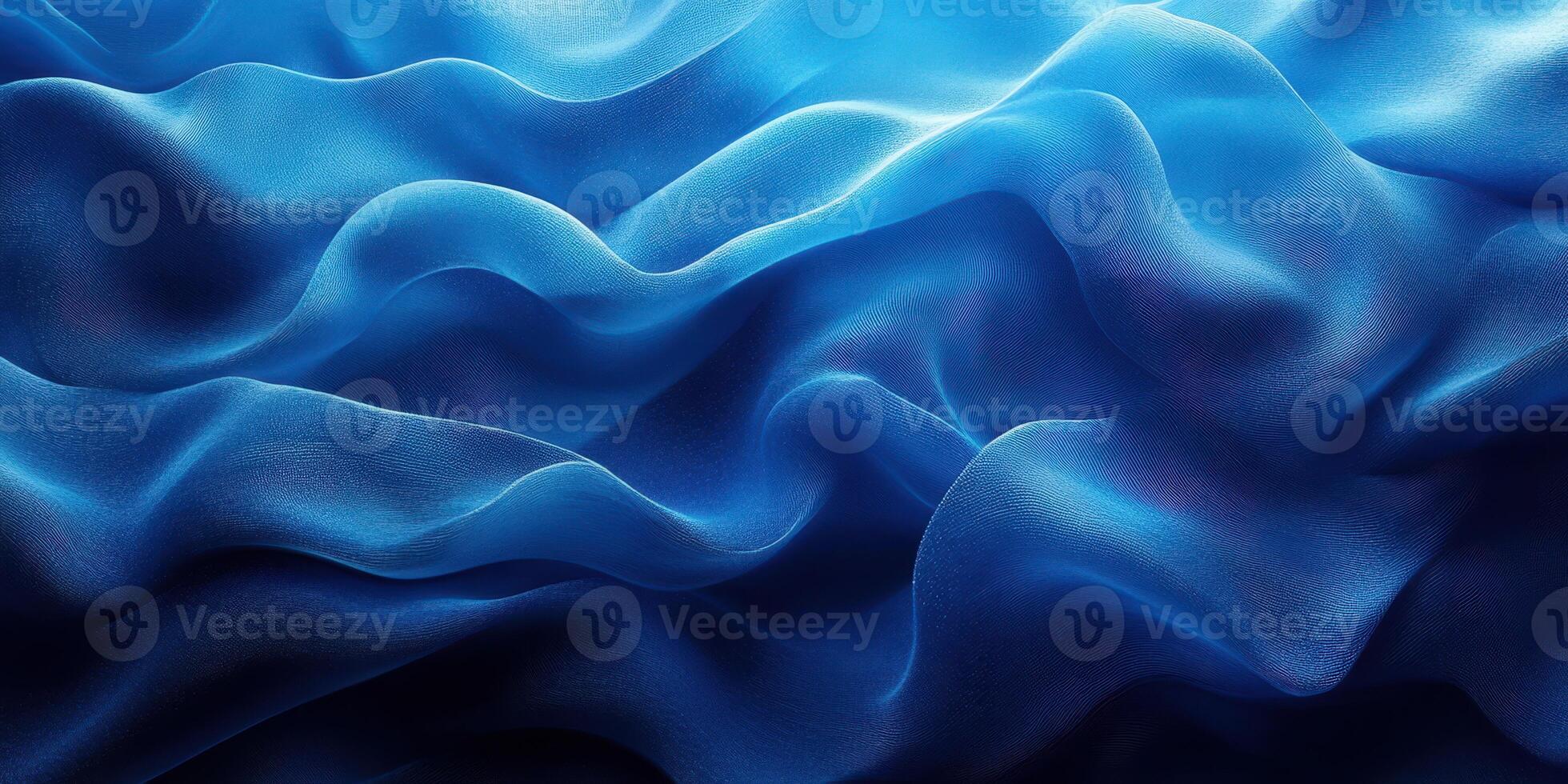 Fluid waves of deep blue fabric create an ethereal texture under soft lighting in a serene setting photo