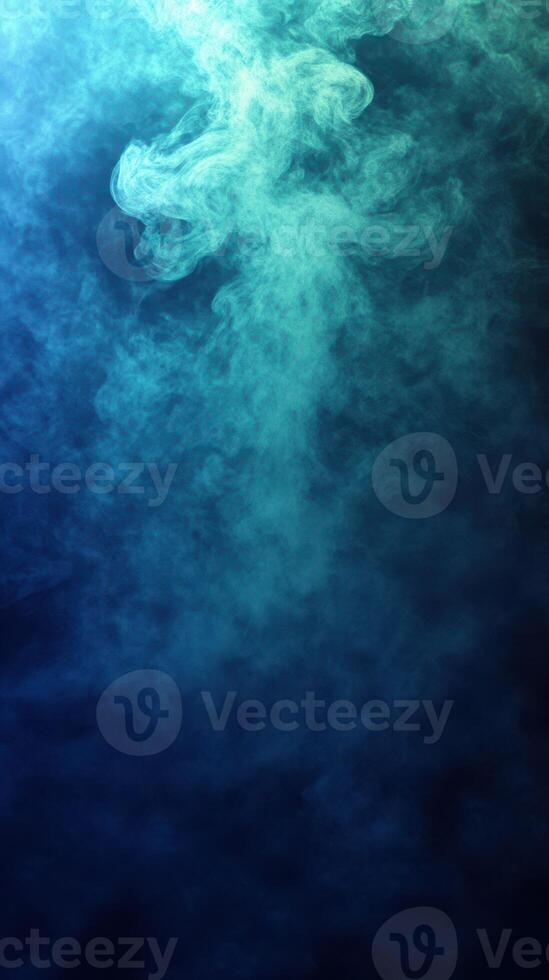 Colorful smoke swirls create an abstract design in a dark environment with blue and green tones photo